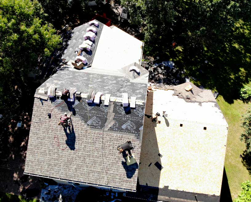 Drone photo of an in progress roofing work with 3 workers