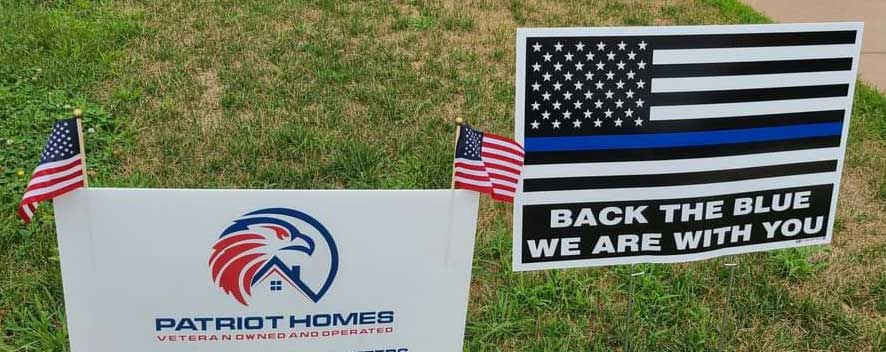 Patriot Homes sign next to Back the Blue sign