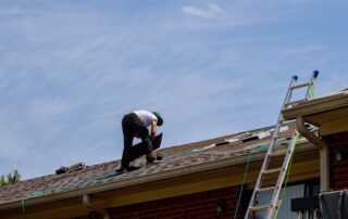 A Construction worker working on a roof and installing new shingles
