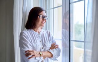 Middle Age business woman looking out of the window into the distance and smiling