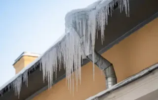 Icicles and Ice Dam forming on top of the gutters because of snowy roof